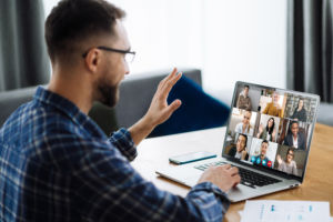 distant work man business freelancer home caucasian laptop group people coworkers online. Video call, online business meeting, briefing. Successful caucasian freelancer waving hand and greeting colleagues during video conference. Distant work, online learning.