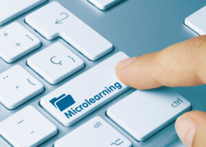 Microlearning Written on Blue Key of Metallic Keyboard. Finger pressing key. Microlearning - Inscription on Blue Keyboard Key.