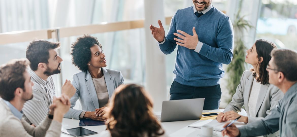 happy-manager-leads-a-meeting-in-the-office-scaled