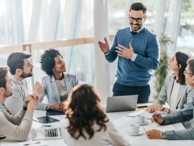 happy-manager-leads-a-meeting-in-the-office-scaled