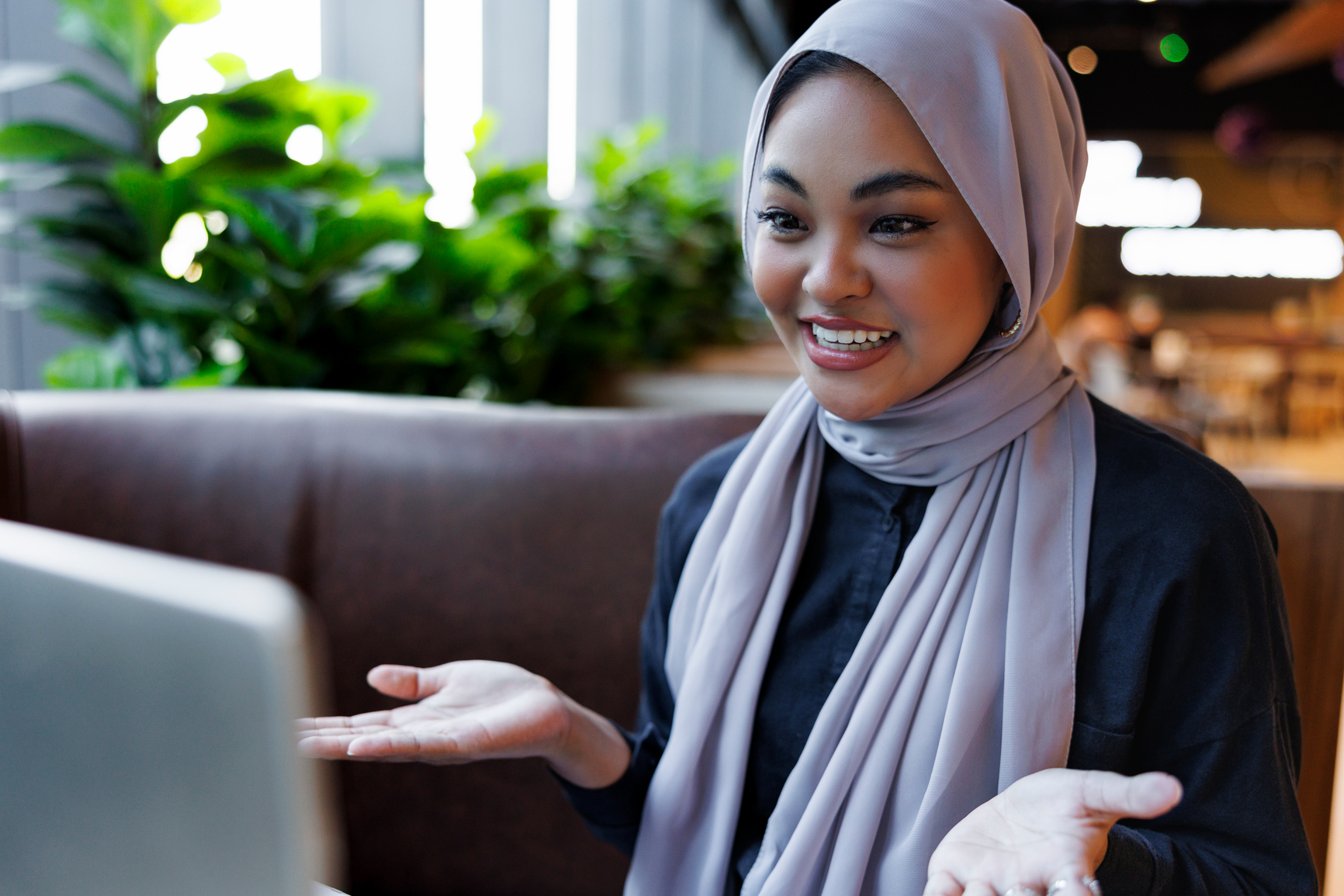 A smiling professional engaged in a flexible 30-minute one-on-one virtual language training session on her laptop.